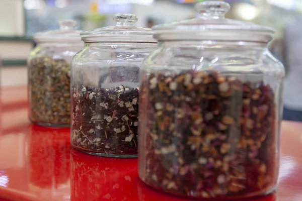 Tea blends in glass jars on the counter of the cafe. Bright colors of tea.