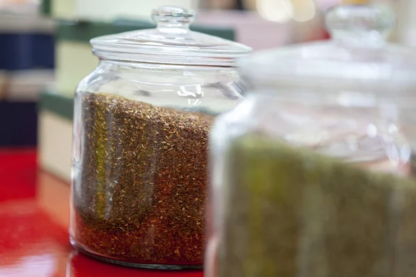 Tea blends in glass jars on the counter of the cafe. Bright colors of tea.