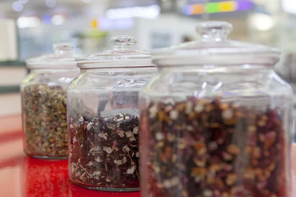 Tea blends in glass jars on the counter of the cafe. Bright colors of tea.