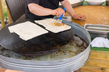 Geleneksel Türk Fırında Tavuklu, yumurta ve tereyağı ile fırça ve bir kalbur üzerinde pişmiş katlanmış bir lezzetli gözleme yapma kişi