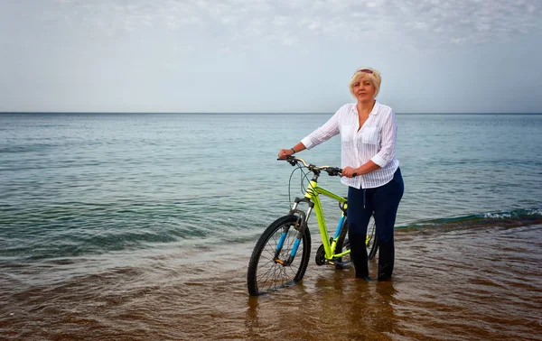 Жінка Штовхає Велосипед Через Неглибокий Серфінг Краю Океану Коли Вона — стокове фото