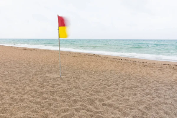 Czerwone Żółte Flagi Ostrzeżenie Lotach Wiatr Bezludnej Plaży Piaszczystej Szary — Zdjęcie stockowe