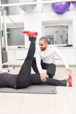 Kadın eğitim ayak kablo crossover makine yardımı salonunda kişisel antrenör ile üzerinde