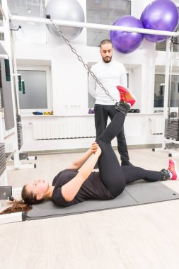 Kadının spor salonunda mat yatarken bacak egzersiz yapması