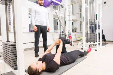 Spor hocası izlerken kadın spor salonunda kablo crossover makinede eğitim