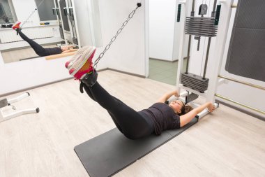 Spor salonunda kablo crossover makine kullanarak kadın eğitim bacaklar