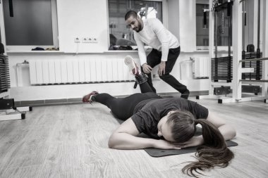 Sağlık ve fitness kavramı içinde kişisel bir eğitmen ile bir mat bir spor salonunda çalışma dışarı bir kadının tek renkli görüntü