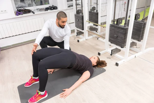 Kadın Kalça Bacak Egzersiz Spor Salonunda Sırasında Yükselterek Yardımcı Antrenör — Stok fotoğraf