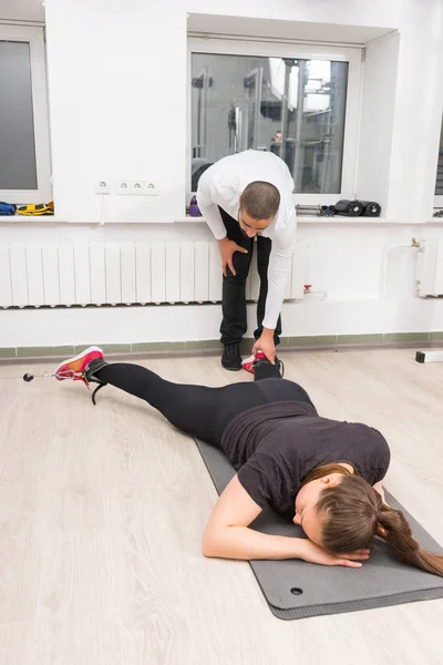 Εκπαιδευτής Βοηθώντας Γυναίκα Κατά Διάρκεια Άσκησης Στο Γυμναστήριο — Φωτογραφία Αρχείου