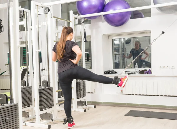 在健身房镜前运动的年轻女子在电缆交叉机上锻炼 — 图库照片