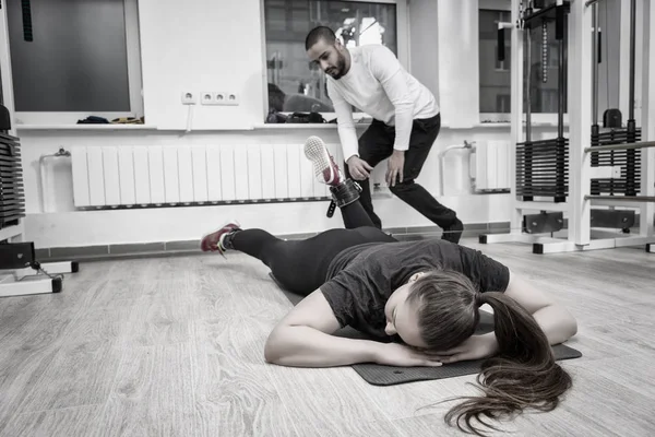 Sağlık ve fitness kavramı içinde kişisel bir eğitmen ile bir mat bir spor salonunda çalışma dışarı bir kadının tek renkli görüntü