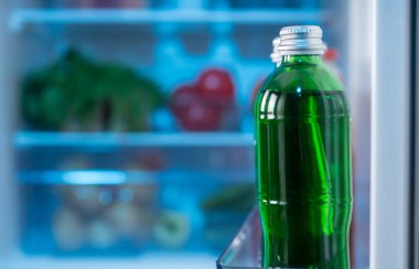 Seçici odak ve kopya alanı bulanık raflar taze gıda ile açık bir buzdolabı kapı tam yeşil şişe