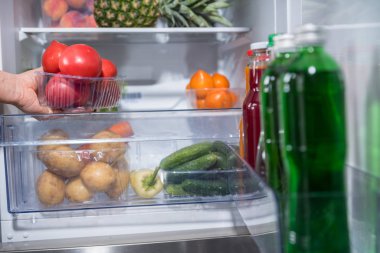 Taze domates ile Plastik Konteyner açık buzdolabından alarak kişi