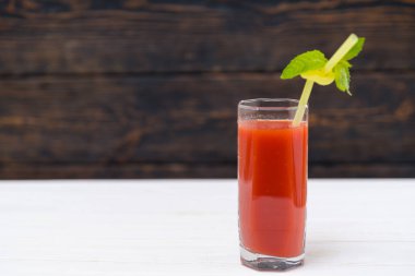 Bardak taze domates suyu ile saman ahşap arka plan karşı nane yaprağı