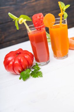 Taze yapılmış domates ve taze meyve ve sebze maddeler yanında kopya alanı ile eğik açılı görünüş ile portakal suyu uzun boylu gözlük