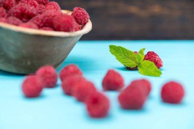 Mavi nane yaprağı tabloyla karşı sulu ahududu kase