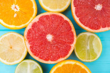 Yarıya Taze narenciye ile limon, limon, portakal ve ruby greyfurt yukarıdan arka plan mavi ahşap üzerine yakından içinde ürün yelpazesine
