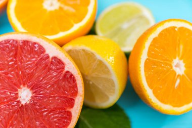 Yarıya taze greyfurt, portakal, limon ve görünümü üzerinde mavi bir arka plan ile odak için ruby greyfurt kadar yakın kireç