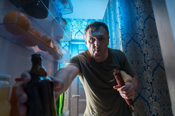 Man Grabbing Bottle Cold Beer Fridge Stands Open Door Refrigerator — Stock Photo, Image