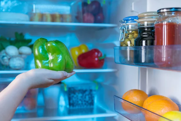 Людина Тримає Свіжий Зелений Перець Проти Відкритого Холодильника — стокове фото