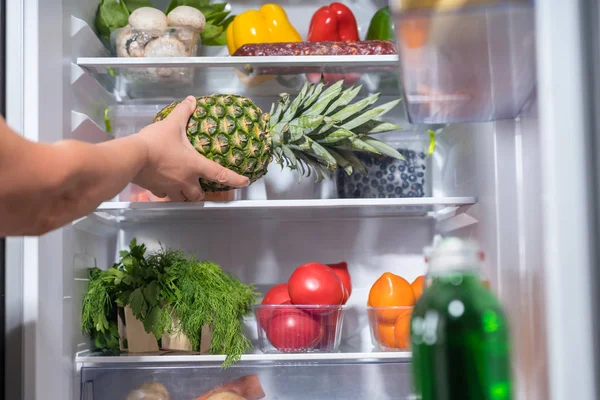 Person Putting Fresh Pineapple Refrigerator Full Food — Stock Photo, Image