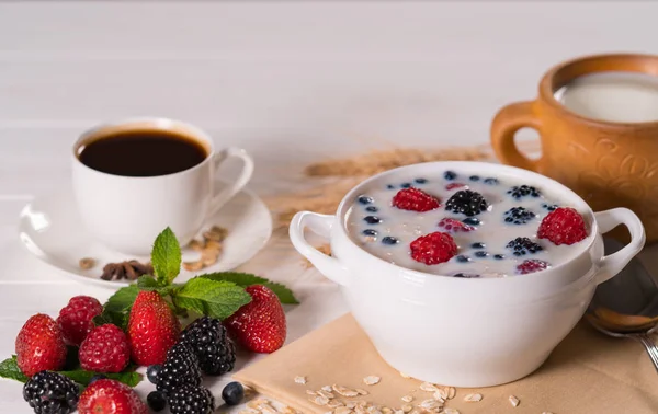 美味的季节性早餐与新鲜的浆果在一碗麦片和牛奶服务与松散的新鲜水果和一杯黑咖啡咖啡 — 图库照片