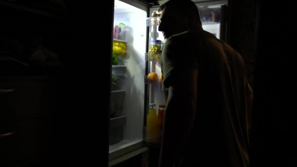 Hombre hambriento con trastorno alimenticio abriendo la nevera — Vídeos de Stock