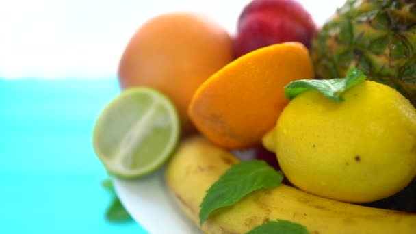 Різні свіжі фрукти подаються на обертовій тарілці — стокове відео
