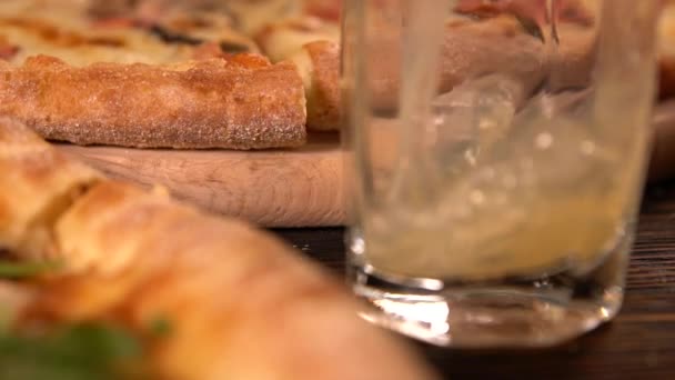 Derramando um copo de suco para acompanhar as pizzas — Vídeo de Stock