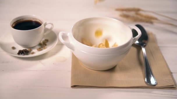 Wheat flakes falling into tiny bowl with handles — Stock Video