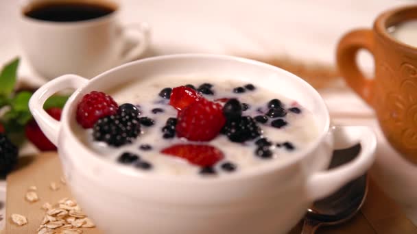 Oats porridge with fresh berries and milk — Stock Video