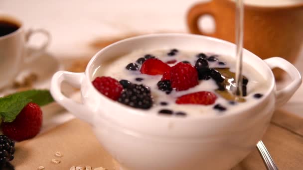 Pouring honey onto a bowl of breakfast cereal — Stock Video