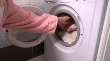 Kirli bir çamaşır makinesi yerleştirerek kadın