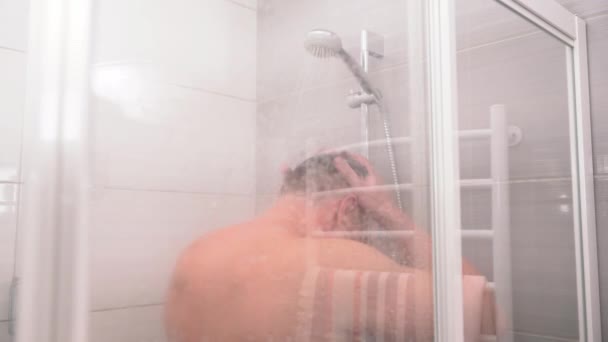 Мужчина средних лет наслаждается горячим горячим душем — стоковое видео