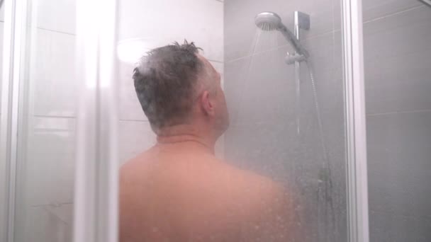 Middle aged man stepping into a shower — Stockvideo