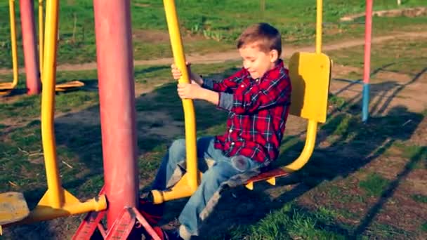 Маленький хлопчик грає на барвистому жовтому сидінні — стокове відео