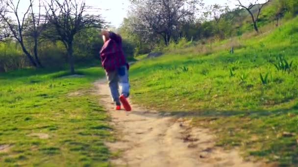 Liten Pojke Hoppar Upp Och Kör Bort Längs Gångstig Genom — Stockvideo