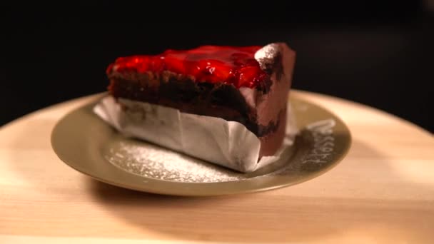 Stuk van gelaagde chocolade cake gegarneerd met vruchten — Stockvideo