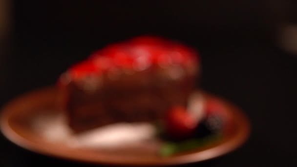 Slice of delicious chocolate cake with berries — Stock Video