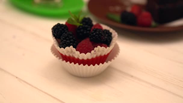 Friss bogyó cupcake és egy szelet csokoládé — Stock videók