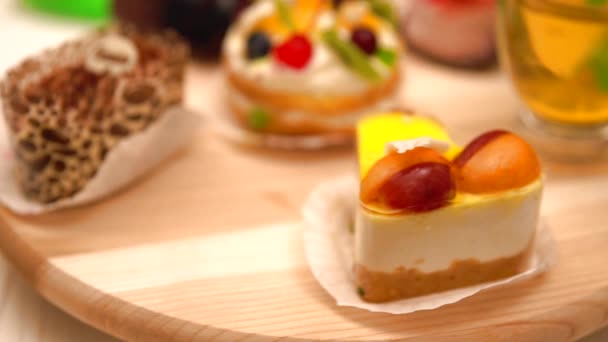 Крутящийся деревянный стенд с изысканными десертами — стоковое видео