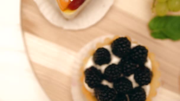 Tartes garnies de fruits frais sur la table tournante — Video