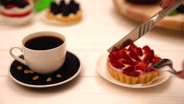 Людина розрізає полуницю і вершковий пиріг — стокове відео