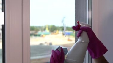 Genç kadın temizlik için pencere cam püskürtme