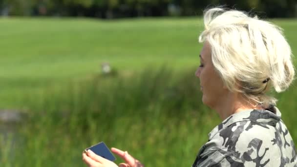 Woman looking down at and swiping on phone screen — Stock Video