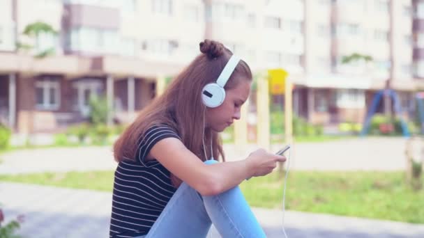 Kvinnliga tonåringen stirrar på telefonen när du sitter ned — Stockvideo