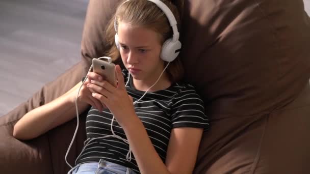 Chica joven escuchando su música en el interior — Vídeos de Stock