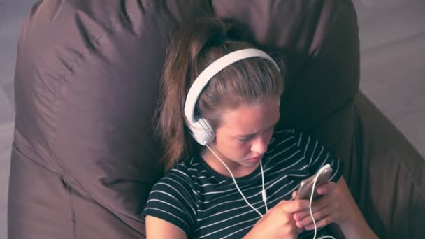 Jong meisje te selecteren van een nieuwe melodie op haar mobiel — Stockvideo