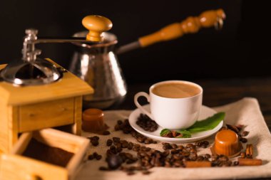 Kare fasulye kahve değirmeni açık çekmece ile yanındaki kapsadığı bez parçası üzerinde oturan dolu espresso fincan