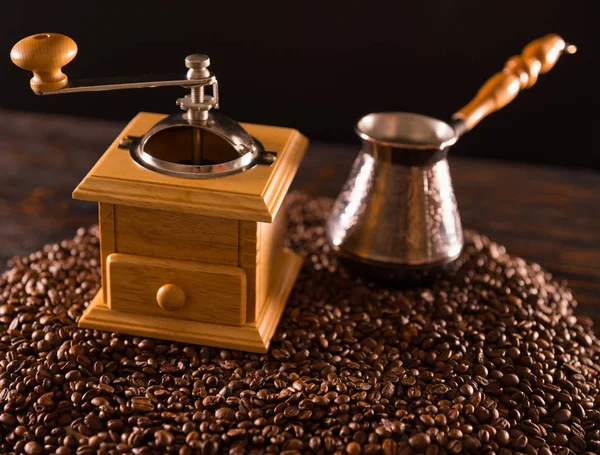 Çapraz havai görünümü siyah fasulye üstüne uzun saplı küçük teneke kutuda ve hafif kahverengi ahşap kahve öğütücü
